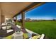 Relaxing covered patio with seating area, overlooking a large grassy backyard at 1907 W Brooke Ln, Queen Creek, AZ 85144