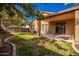 Landscaped backyard with covered patio, grassy area, and gravel at 45759 W Morning View Ln, Maricopa, AZ 85139