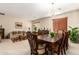 Formal dining room with a large wood table, chandelier, and adjacent living space at 45759 W Morning View Ln, Maricopa, AZ 85139