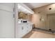 Modern bathroom with a walk-in shower, double vanity, and wood-look floors at 14524 W Sentinel Dr, Sun City West, AZ 85375