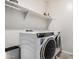 Laundry room with washer, dryer, and overhead shelving at 18625 W Elm St, Goodyear, AZ 85395