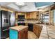 L-shaped kitchen with wood cabinets, tile counters, and island at 1965 Diamondback Dr, Wickenburg, AZ 85390