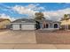 Gray house with three-car garage, landscaped yard, and American flag at 2328 N Roca St, Mesa, AZ 85213