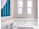 Bathroom with corner bathtub and two windows at 3104 E Broadway Rd # 22, Mesa, AZ 85204