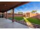 Covered patio with artificial turf, stone accents, and access to the backyard at 47012 N New River Rd, New River, AZ 85087