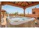 Hot tub with surrounding patio and desert landscape view at 47012 N New River Rd, New River, AZ 85087