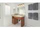 Clean bathroom with a wooden vanity and updated light fixtures at 10652 W Saratoga Cir, Sun City, AZ 85351