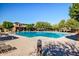 Community pool with surrounding lounge chairs and clubhouse at 17539 W Buchanan St, Goodyear, AZ 85338