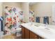 Bathroom boasts dual sinks, a shower/tub combo and decorative shower curtain at 4719 W Silva Dr, New River, AZ 85087