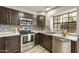 Well-equipped kitchen with dark cabinets, stainless steel appliances, and granite countertops at 4901 E Kelton Ln # 1006, Scottsdale, AZ 85254