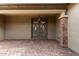 Double door entry with a covered porch and brick columns at 6523 N 135Th Dr, Glendale, AZ 85307