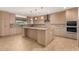 Modern kitchen with light wood cabinets, granite counters, and island at 6523 N 135Th Dr, Glendale, AZ 85307
