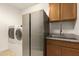 Laundry room with stainless steel refrigerator, washer, dryer, and a sink at 6523 N 135Th Dr, Glendale, AZ 85307