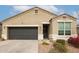 Tan house with dark gray garage door and landscaping at 8522 W Georgetown Way, Florence, AZ 85132