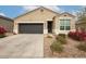 Tan house with dark gray garage door and landscaping at 8522 W Georgetown Way, Florence, AZ 85132