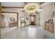 Spacious entryway with tile flooring, wood beams, and a large chandelier at 1065 Buckboard Trl, Wickenburg, AZ 85390