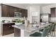 Modern kitchen with dark cabinetry, granite island, and stainless steel appliances at 12157 E Aster Ln, Florence, AZ 85132