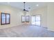 Bright living room with vaulted ceilings, ceiling fan, and sliding glass door to backyard at 15896 N 182Nd Ave, Surprise, AZ 85388