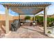 Covered outdoor kitchen perfect for summer barbecues with a pergola overhead at 2949 N Acacia Way, Buckeye, AZ 85396