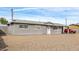 Gray single story home with a gravel front yard and carport at 9042 E Marguerite Ave, Mesa, AZ 85208