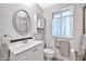 Bathroom with white vanity, toilet, and oval mirror at 10205 W Royal Oak Rd, Sun City, AZ 85351