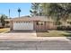 Brick ranch home with a white garage door and mature landscaping at 10205 W Royal Oak Rd, Sun City, AZ 85351