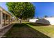 Large backyard with grass, trees, and a patio at 10728 W Cheryl Dr, Sun City, AZ 85351