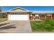 House exterior featuring a white garage door, well-manicured lawn, and a brick walkway at 10728 W Cheryl Dr, Sun City, AZ 85351