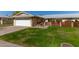 House exterior featuring a white garage door, well-manicured lawn, and a brick walkway at 10728 W Cheryl Dr, Sun City, AZ 85351