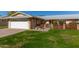 House exterior featuring a white garage door, well-manicured lawn, and a brick walkway at 10728 W Cheryl Dr, Sun City, AZ 85351