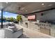 Covered patio with outdoor kitchen, TV, and seating at 11946 E Cavedale Dr, Scottsdale, AZ 85262