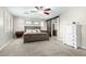 Main bedroom with a dresser, large bed, and barn door leading to bathroom at 29752 N 69Th Dr, Peoria, AZ 85383