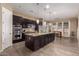 Modern kitchen with dark wood cabinets, granite island, and stainless steel appliances at 3234 E Ian Dr, Phoenix, AZ 85042