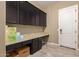 Laundry room with dark brown cabinets and granite countertops at 3234 E Ian Dr, Phoenix, AZ 85042