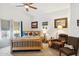 Main bedroom with wood bed frame and comfortable armchair at 45467 W Dirk St, Maricopa, AZ 85139