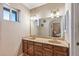 Double vanity bathroom with large mirror and wood cabinets at 17638 N 36Th Ave, Glendale, AZ 85308