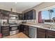 Modern kitchen with dark wood cabinets, granite counters, and stainless steel appliances at 17638 N 36Th Ave, Glendale, AZ 85308