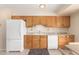 Kitchen features white appliances and oak cabinets at 18001 N 99Th Dr, Sun City, AZ 85373