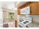 Kitchen with oak cabinets, white appliances, and backyard view at 18001 N 99Th Dr, Sun City, AZ 85373