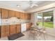 Bright kitchen with oak cabinets, white appliances, and view to backyard at 18001 N 99Th Dr, Sun City, AZ 85373