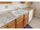 Kitchen features double sink, light wood cabinets, and speckled countertops at 18001 N 99Th Dr, Sun City, AZ 85373