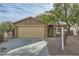 Beige house with a two-car garage and a landscaped front yard at 25763 W Satellite Ln, Buckeye, AZ 85326