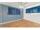 Bedroom with blue striped walls, ceiling fan, and brown flooring at 5701 N 12Th Pl, Phoenix, AZ 85014