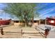 Tan single story house with a large tree and a wooden fence at 5936 W Berkeley Rd, Phoenix, AZ 85035