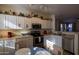 Bright kitchen boasts white cabinets, stainless steel appliances, and breakfast nook at 964 E Ranch Rd, Gilbert, AZ 85296