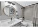 Modern bathroom with gray tile and a round mirror at 9711 E Mountain View Rd # 1516, Scottsdale, AZ 85258