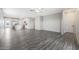 Spacious living room with grey wood-look flooring and kitchen view at 10359 N 115Th Ave, Youngtown, AZ 85363