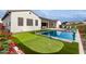 Expansive backyard featuring a pool, putting green, and lush landscaping at 10986 N Northfield St, Surprise, AZ 85388