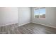 Simple bedroom with grey wood-look floors and window blinds at 11501 W Deanne Dr, Youngtown, AZ 85363