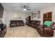 Relaxing living room featuring brown leather furniture and ceiling fan at 11867 W Grant St, Avondale, AZ 85323